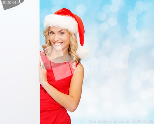 Image of smiling young woman in santa hat with white board