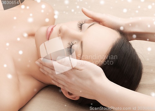 Image of beautiful woman getting face or head massage