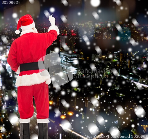 Image of man in costume of santa claus writing something