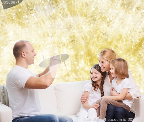 Image of happy family with camera at home