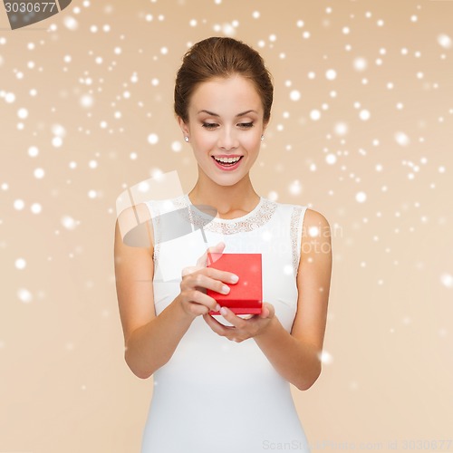Image of smiling woman holding red gift box
