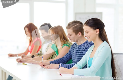 Image of smiling students with textbooks at school