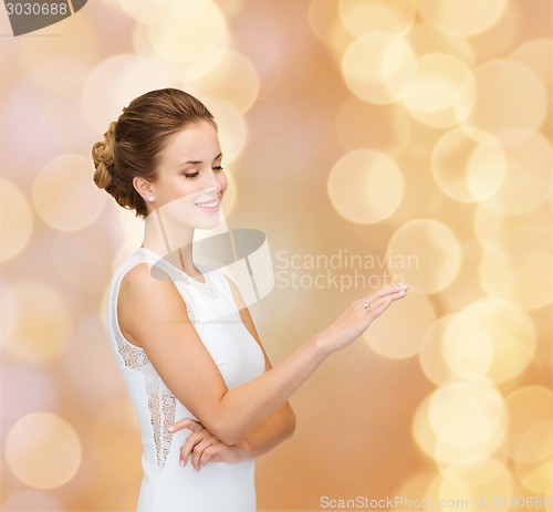 Image of smiling woman in white dress with diamond ring