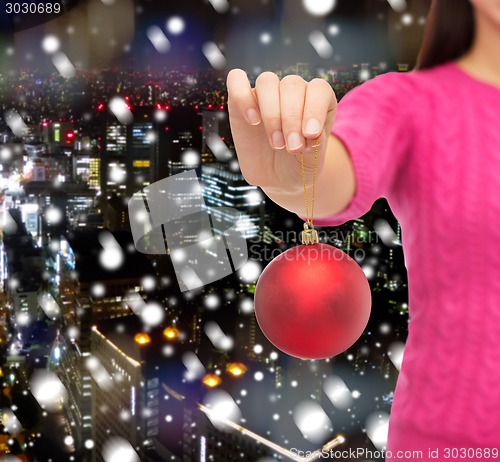 Image of close up of woman in sweater with christmas ball