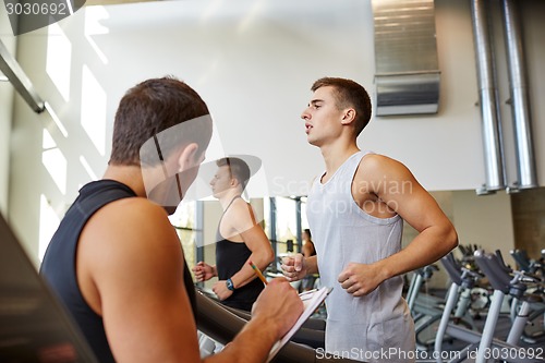 Image of men exercising on treadmill in gym