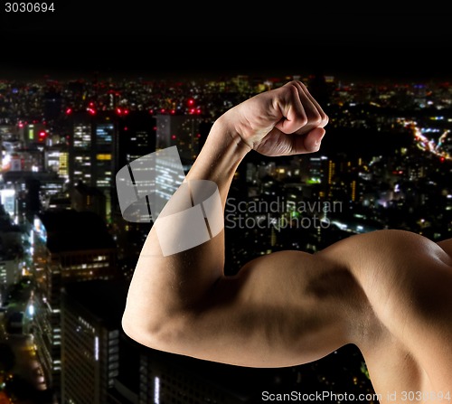 Image of close up of young man showing biceps