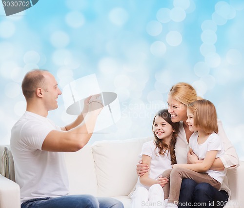 Image of happy family with camera at home