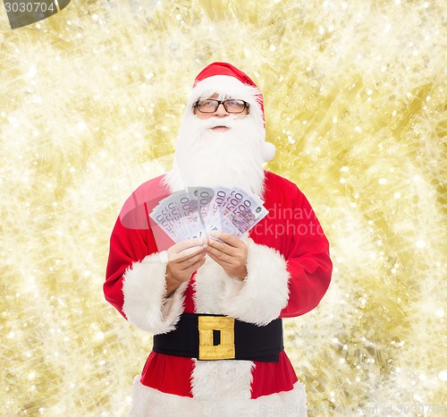 Image of man in costume of santa claus with euro money