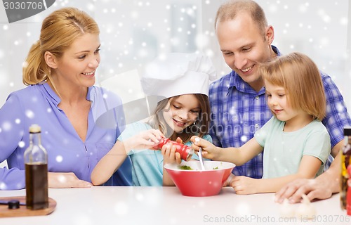 Image of happy family with two kids making salad at home