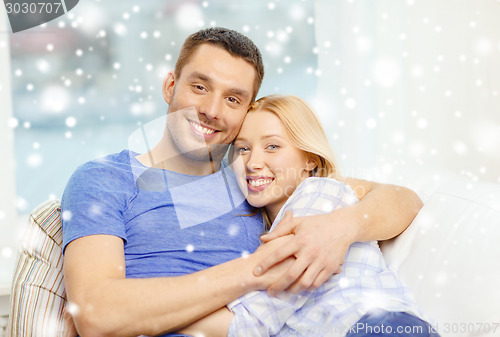 Image of happy couple hugging at home