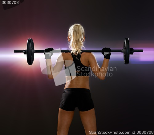 Image of sporty woman exercising with barbell from back