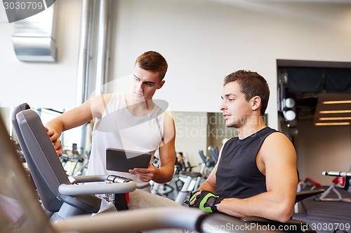 Image of men exercising on gym machine