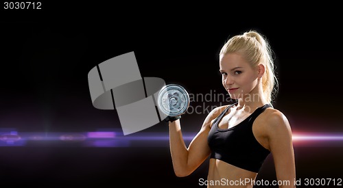 Image of young sporty woman with heavy steel dumbbell