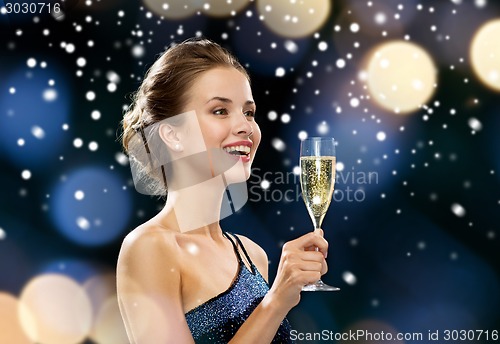 Image of smiling woman holding glass of sparkling wine