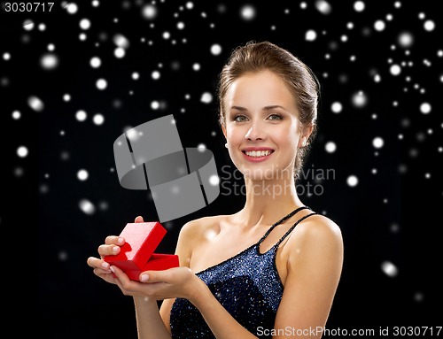 Image of smiling woman holding red gift box