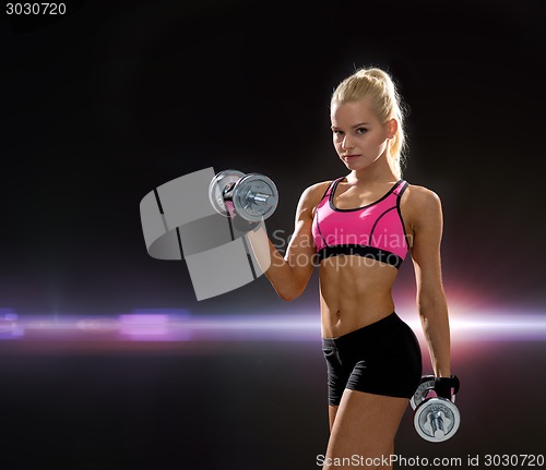 Image of sporty woman with heavy steel dumbbells