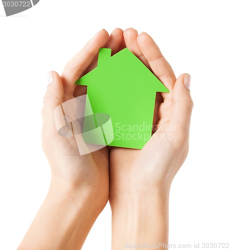 Image of hands holding green paper house