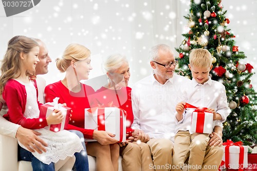 Image of smiling family with gifts at home