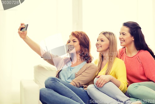 Image of teenage girls taking selfie with smartphone