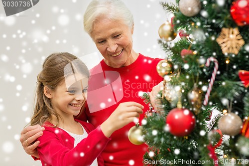 Image of smiling family decorating christmas tree at home