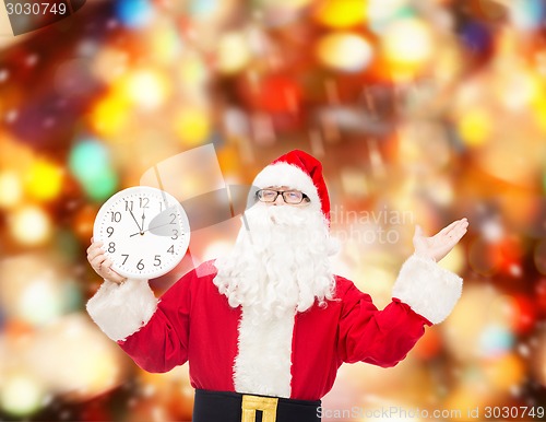 Image of man in costume of santa claus with clock