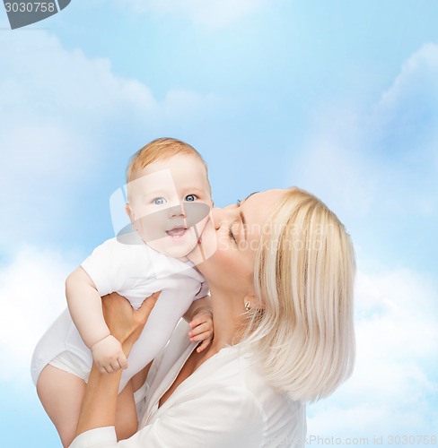 Image of happy mother kissing smiling baby