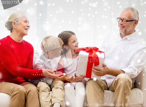 Image of smiling grandparents and grandchildren with gift