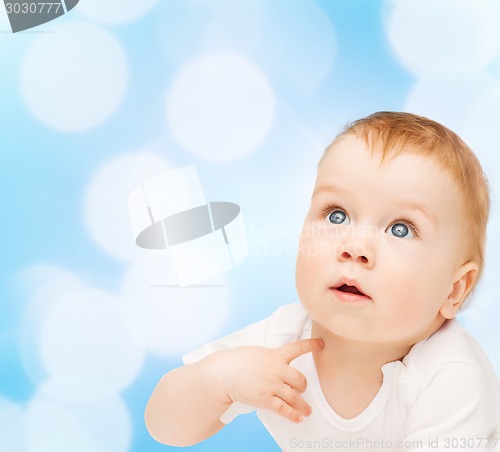 Image of curious baby lying on floor and looking up