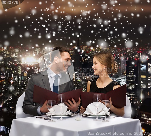 Image of smiling couple with menus at restaurant