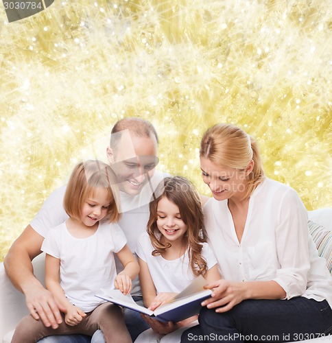 Image of happy family with book at home
