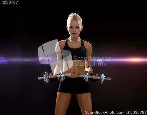 Image of sporty woman with heavy steel dumbbells