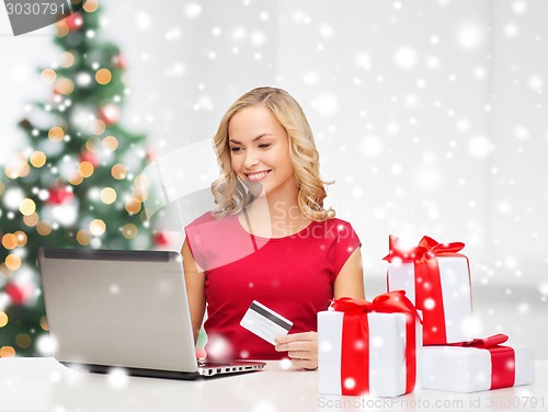 Image of woman with gift boxes and laptop computer