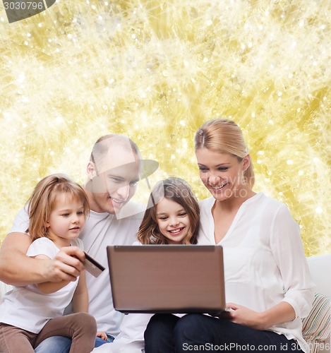 Image of happy family with laptop computer and credit card