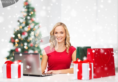 Image of woman with gift boxes and laptop computer