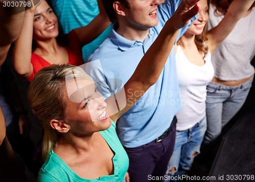 Image of smiling friends at concert in club