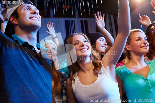 Image of smiling friends at concert in club