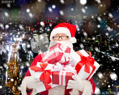 Image of man in costume of santa claus with gift boxes