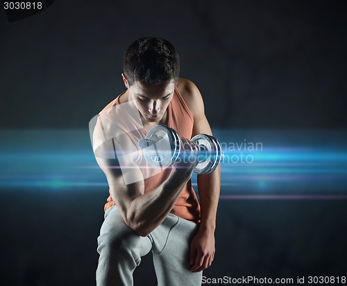 Image of young man with dumbbell flexing biceps