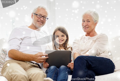 Image of smiling family with tablet pc at home