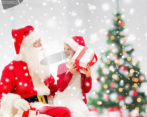 Image of smiling little girl with santa claus and gifts