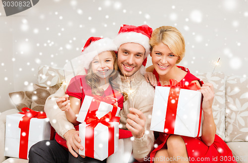 Image of happy family with gifts and sparklers