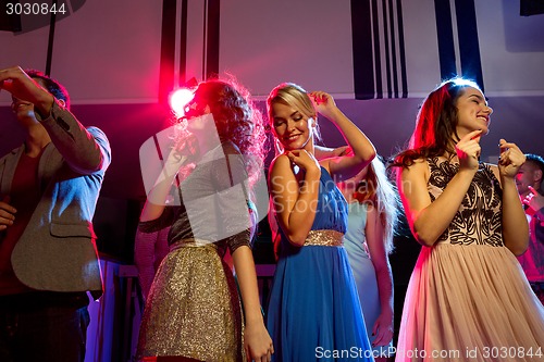 Image of smiling friends dancing in club