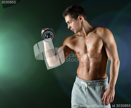 Image of young man with dumbbell flexing biceps