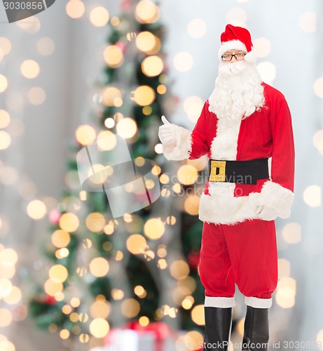 Image of man in costume of santa claus showing thumbs up