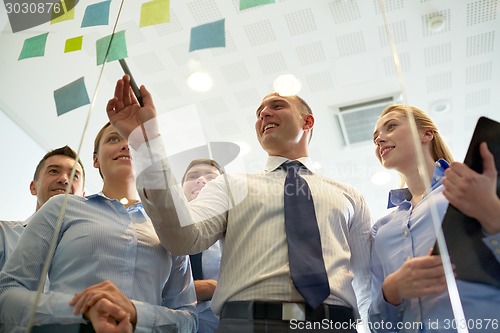 Image of smiling business people with marker and stickers