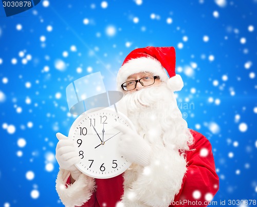 Image of man in costume of santa claus with clock