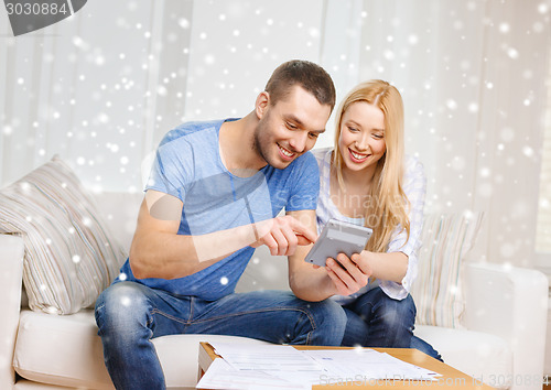 Image of happy couple with papers and calculator at home