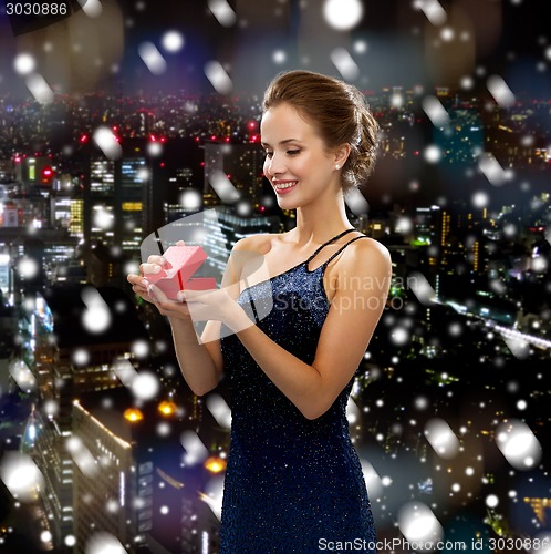 Image of smiling woman holding red gift box
