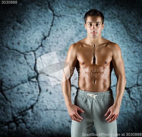 Image of young male bodybuilder with bare muscular torso