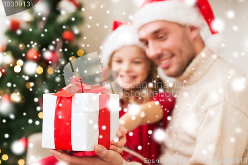 Image of smiling father and daughter holding gift box